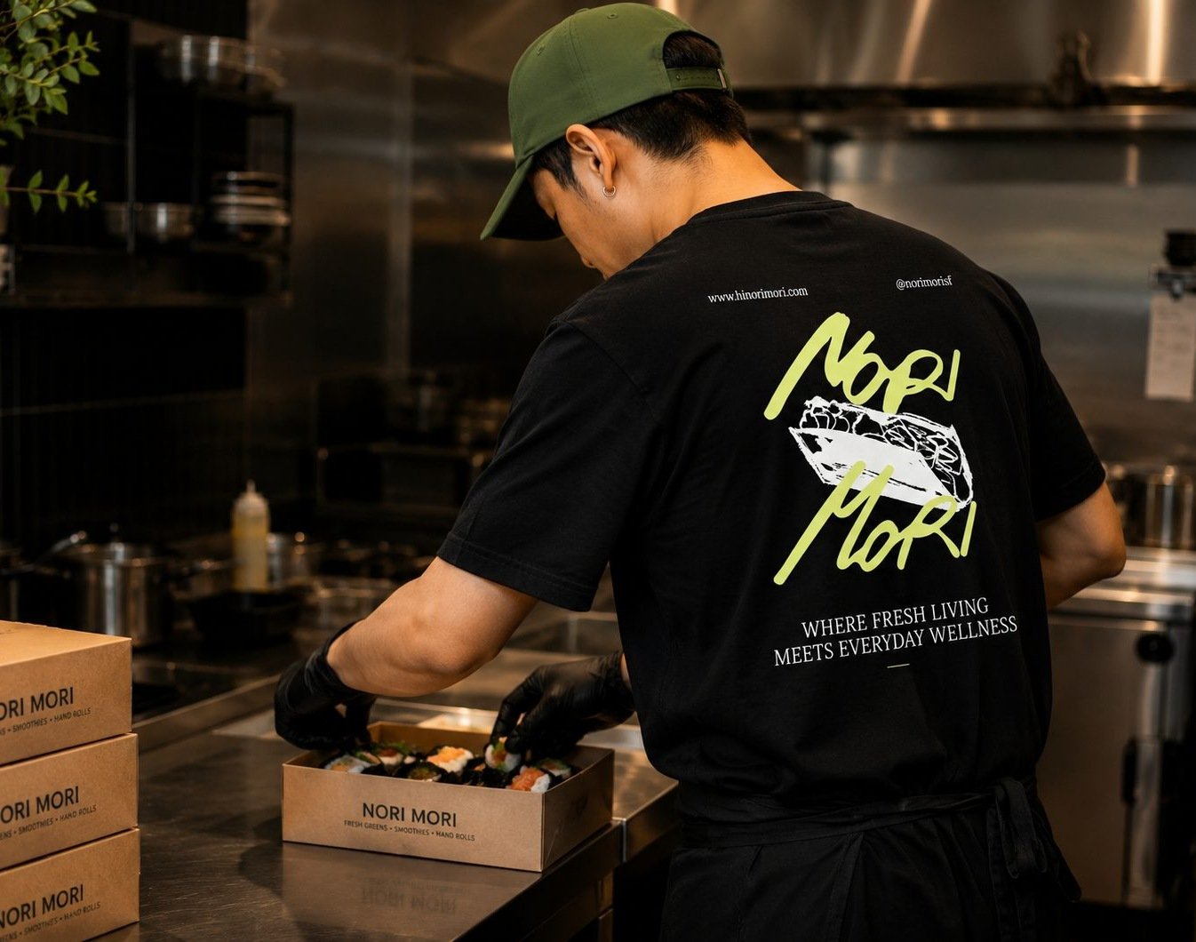 A Nori Mori team member packing hand rolls in the kitchen, wearing the branded tee